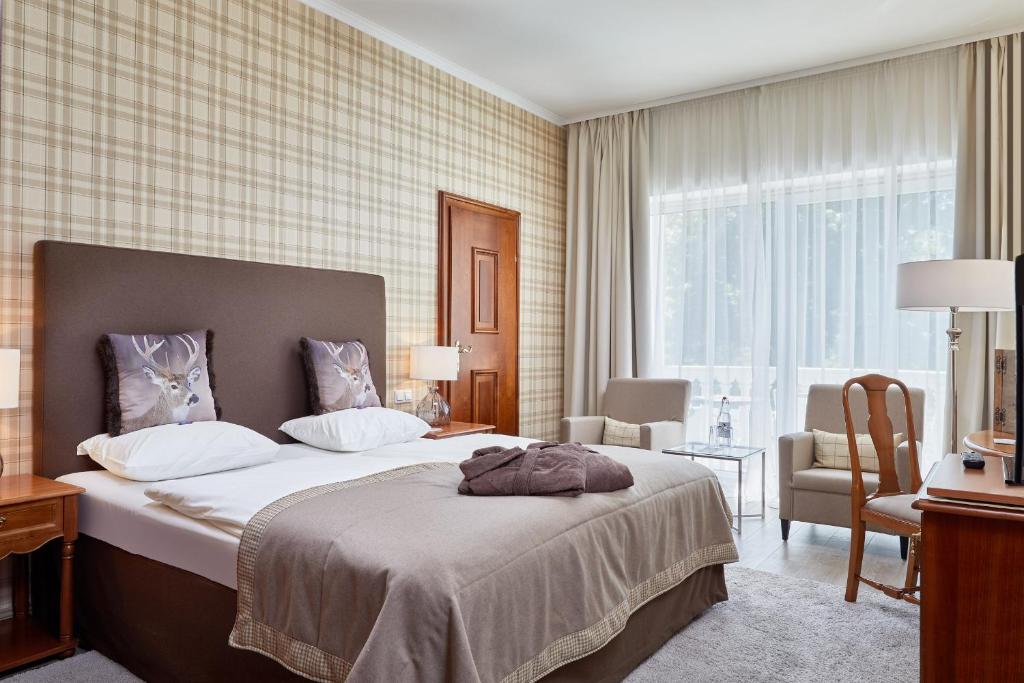 Mūsdienīgs viesnīcas numurs ar divguļamo gultu, komfortablām krēslām un lieliem logiem, kas nodrošina dabisko apgaismojumu. Interjers ir veidots ar modernu, neitrālu krāsu paleti un elegantiem aksesuāriem.