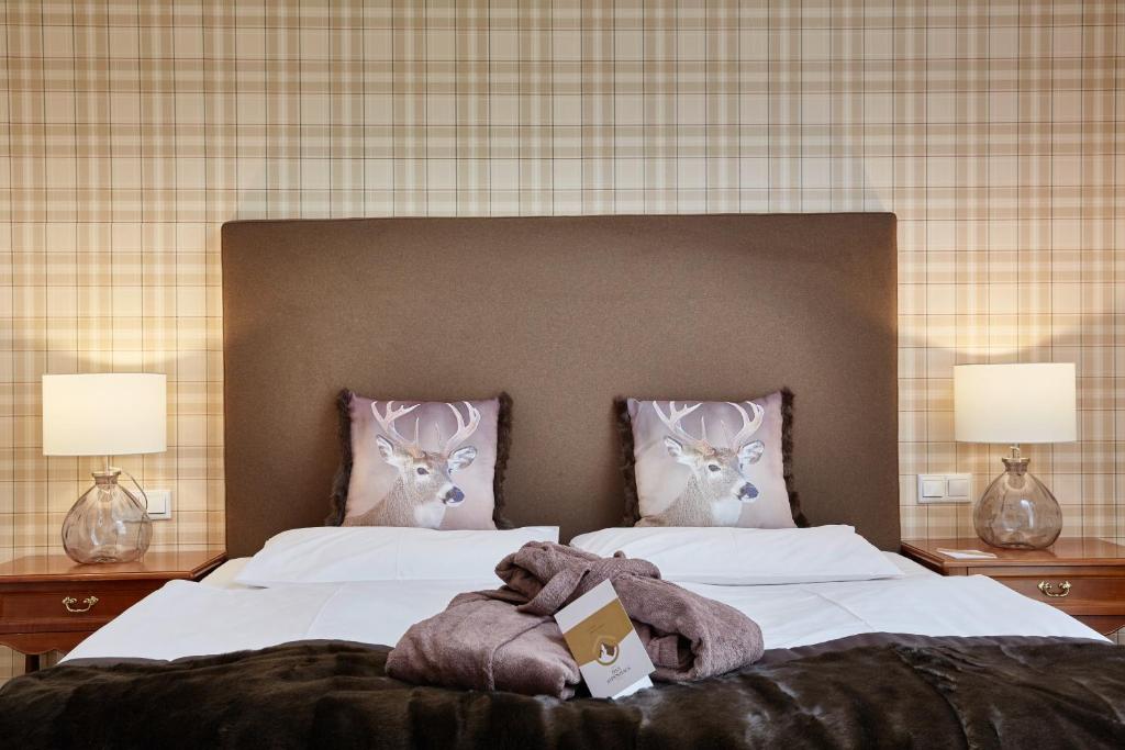 Mūsdienīga guļamistaba ar diviem spilveniem ar stāvošiem briežiem uz dekoratīvām atpūtas gultām, siltu apgaismojumu un elegantu interjeru. Ideāla vieta relaksācijai un komfortam.