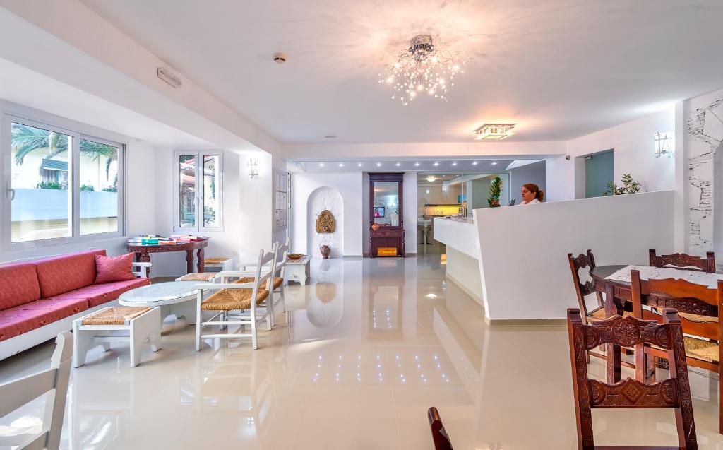 Mūsdienīga viesnīcas recepcija ar elegantu interjeru, kurā ir gaišas krāsas, komfortabli dīvāni un galds. Telpa ir plaša un gaiša, radot viesmīlīgu atmosfēru.