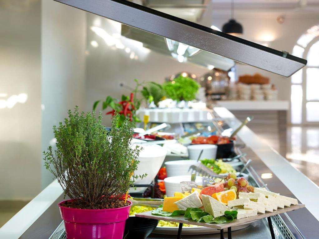 Svaigu dārzeņu un sieru bufete ar garšaugiem, kas izkārtoti elegantā vidē. Ideāls attēls, kas attēlo veselīgu ēdienu izvēli un viesmīlību.