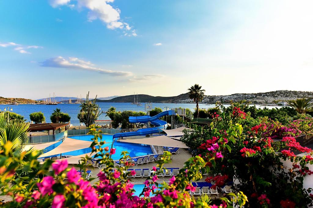 Skats uz baseinu un piekrasti Parkım Ayaz Hotel, ziedi un jūras laivas.
