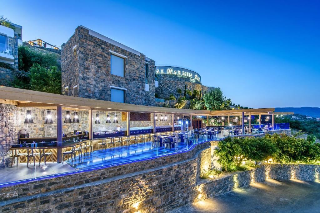 Royal Marmin Bay Boutique & Art Hotel terase ar apgaismojumu piekrastē, vakara ainava
