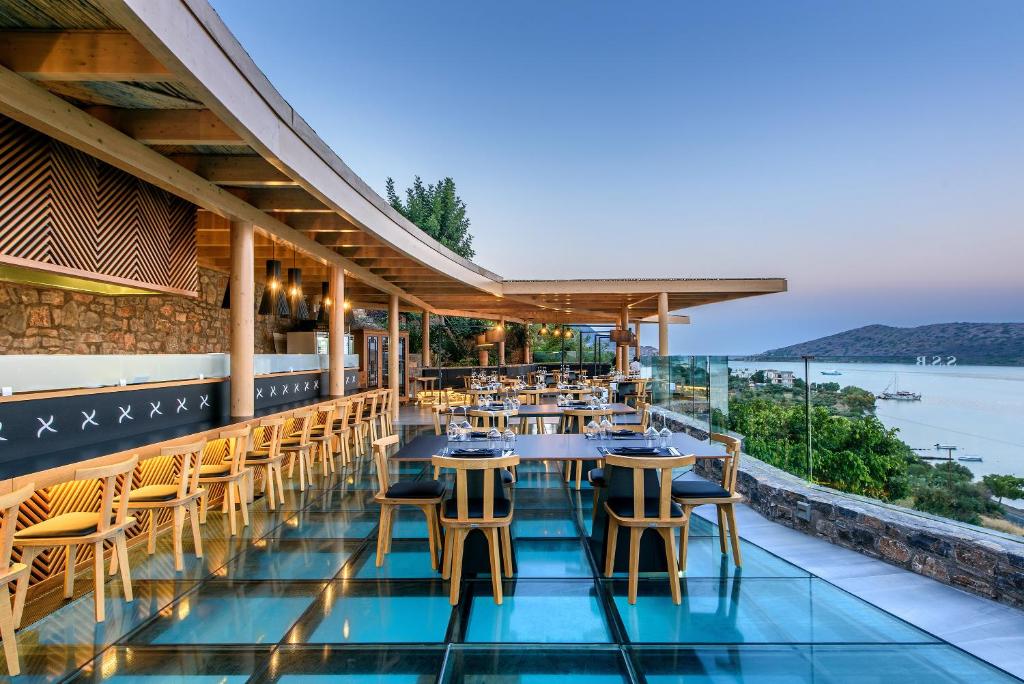 Restorāns ar terasi Royal Marmin Bay Boutique & Art Hotel piekrastē, ar stikla grīdu.