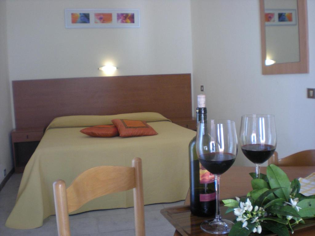 Svaigā un mājīgā guļamistabā ir liels gultas rāmja elements ar dzeltenu gultas veļu, kā arī divi vīna glāzes un pudele uz galda. Interjeru papildina mākslas darbi un spogulis.