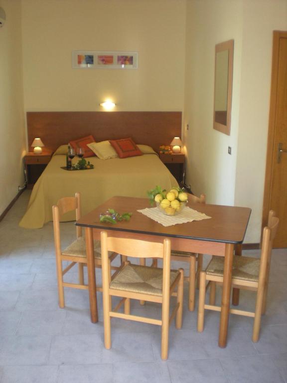 Mūsdienīga viesistaba ar gultu un ēdamgaldu, dekorēta ar augļiem un zaļumiem, radot mājīgu atmosfēru. Ideāla vieta relaksācijai un ērtai atpūtai.