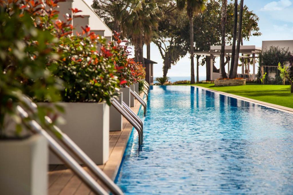 Acanthus & Cennet Barut Collection viesnīcas baseins ar ziediem un palmām