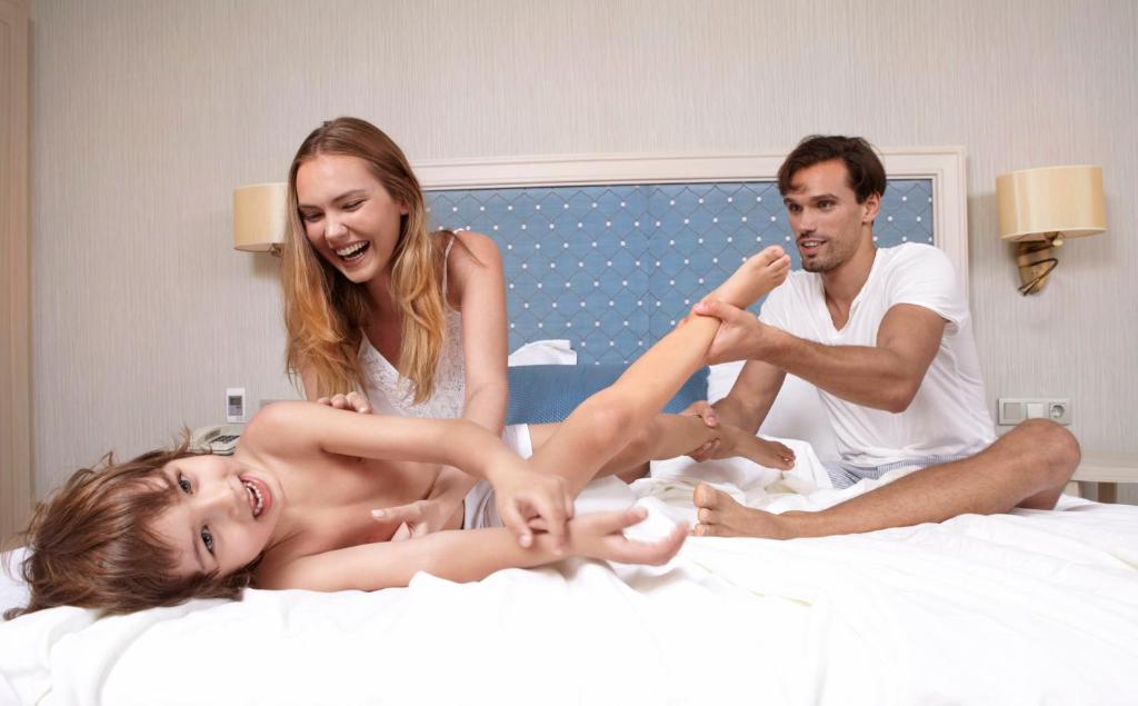 Ģimene spēlējas un smejas Marti Myra Hotel numurā.