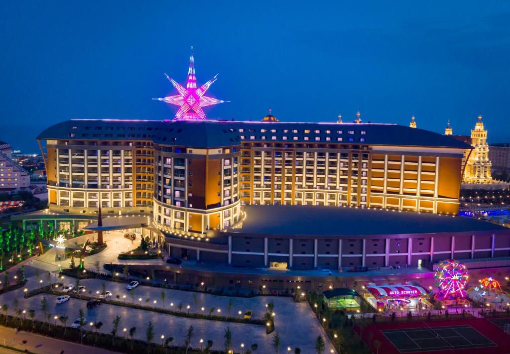 Royal Seginus viesnīca piekrastē naktī ar spilgtu zvaigzni uz jumta.