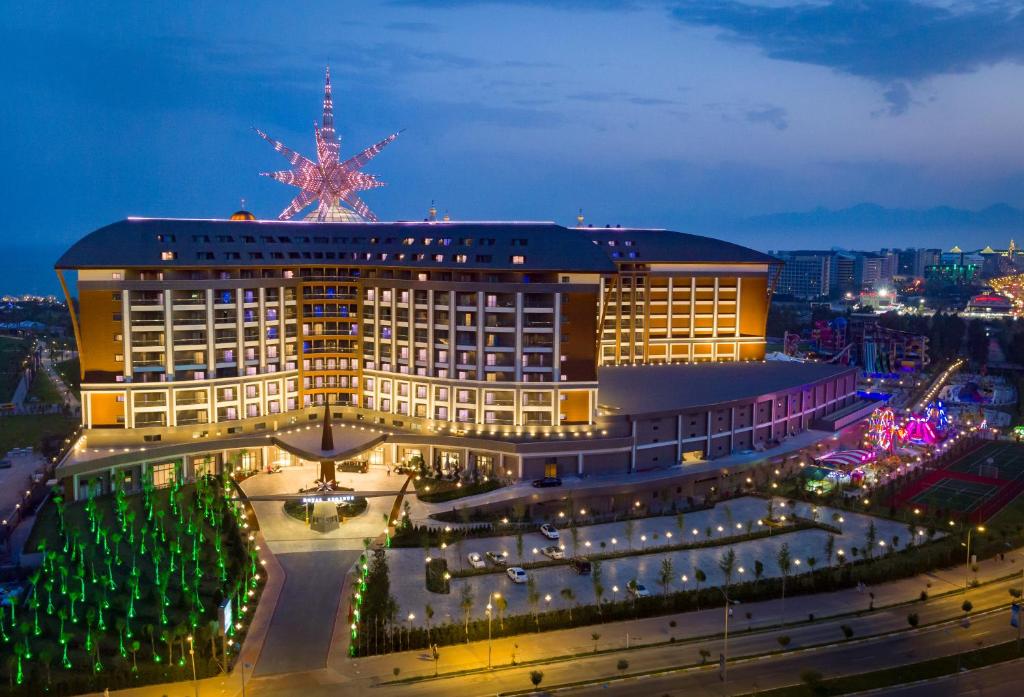 Royal Seginus viesnīca piekrastē ar gaismas dekorācijām un apkārtējo aktivitāšu zonu.