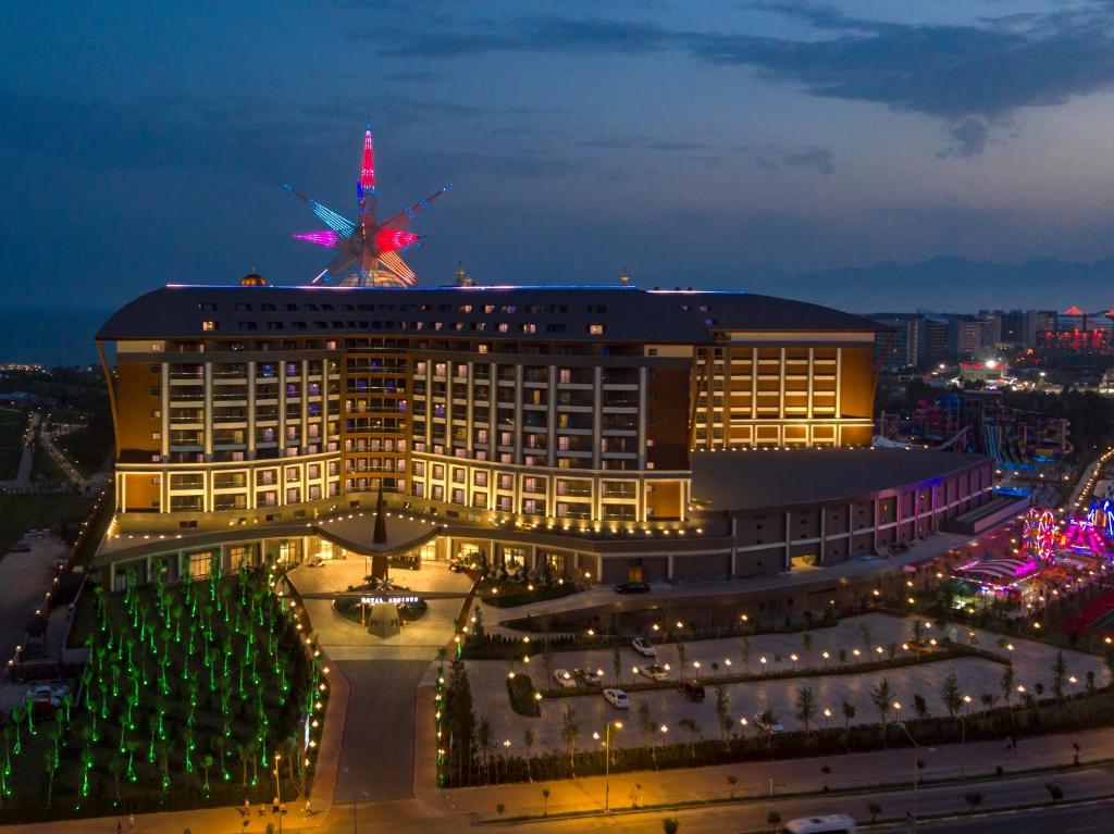 Royal Seginus viesnīca naktī ar krāsainām gaismām un apkārtējo ainavu.