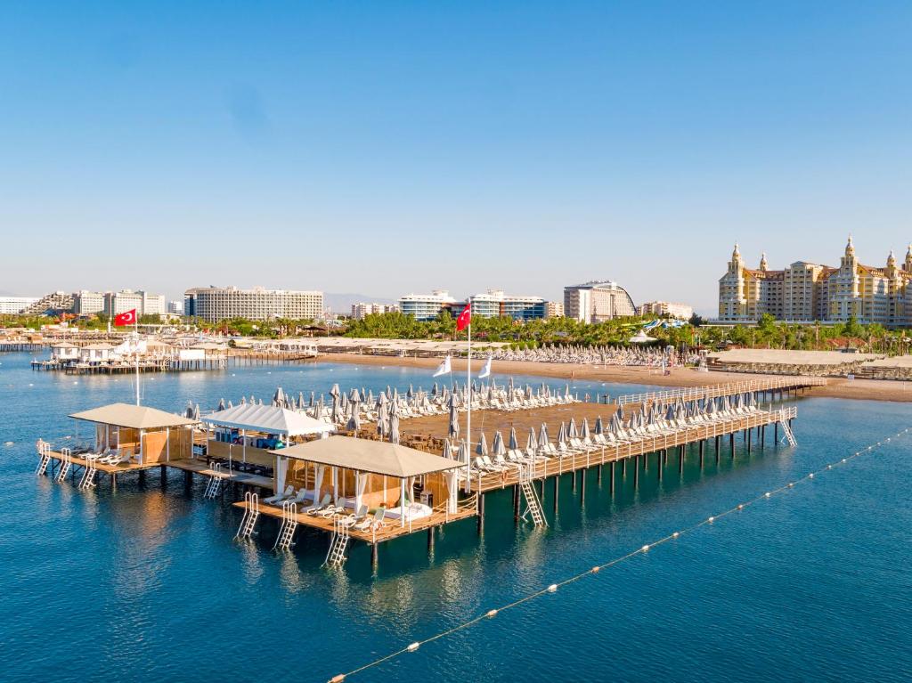 Royal Seginus pludmales zona ar saulessargiem un koka tiltu piekrastē.