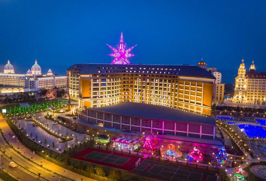 Royal Seginus viesnīca ar apgaismojumu piekrastē naktī.