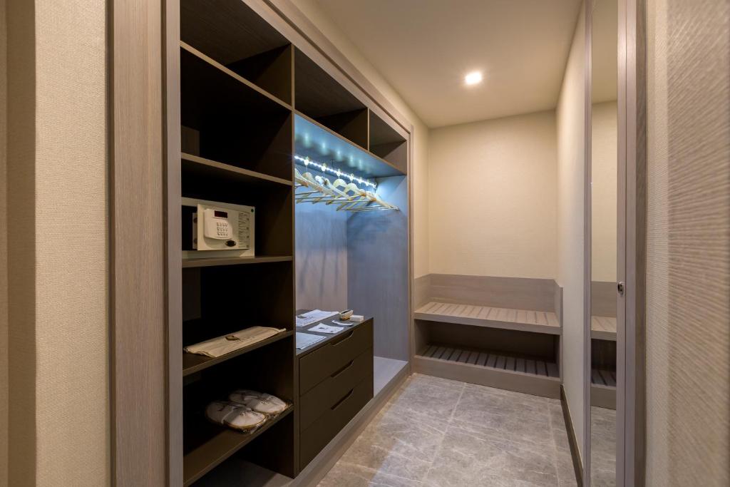 Moderna drēbju uzglabāšana Royal Seginus viesnīcā ar plauktiem un spoguli.