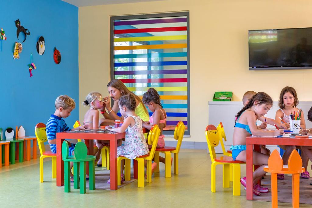 Bērni radoši darbojas bērnu istabā viesnīcā Royal Seginus.