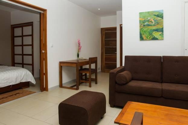 Hotel Plumeria numurs ar dīvānu un guļamistabu.