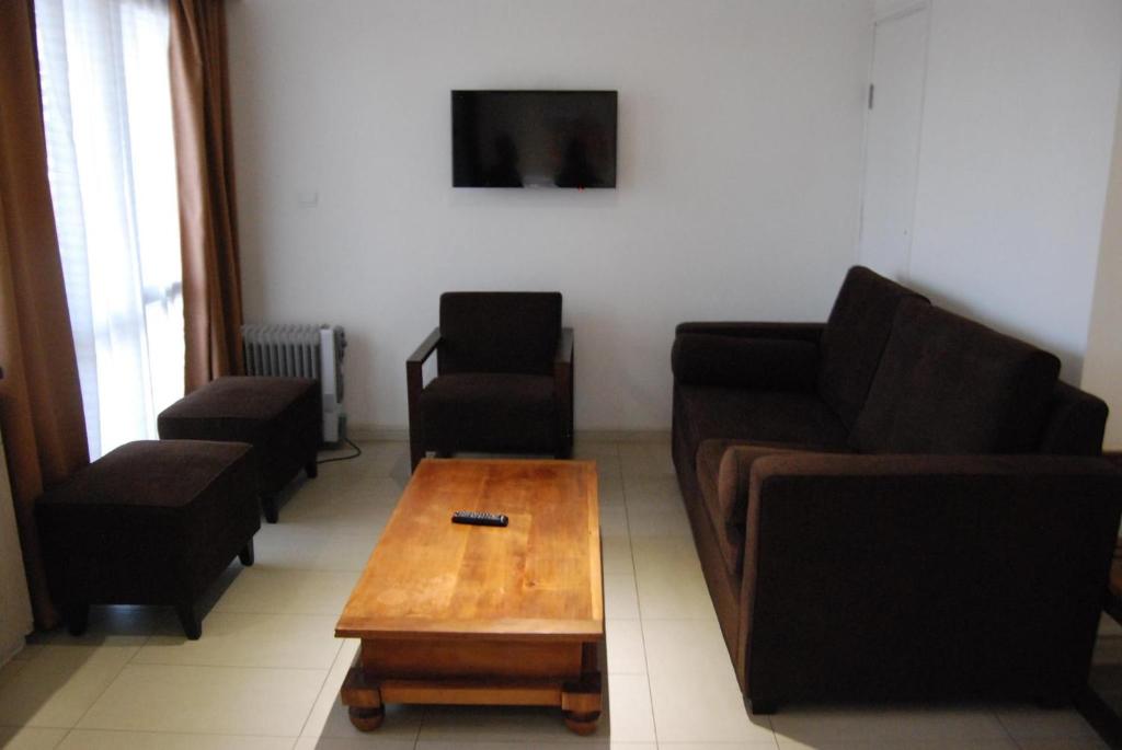 Hotel Plumeria numurs ar viesistabas zonu un televizoru.