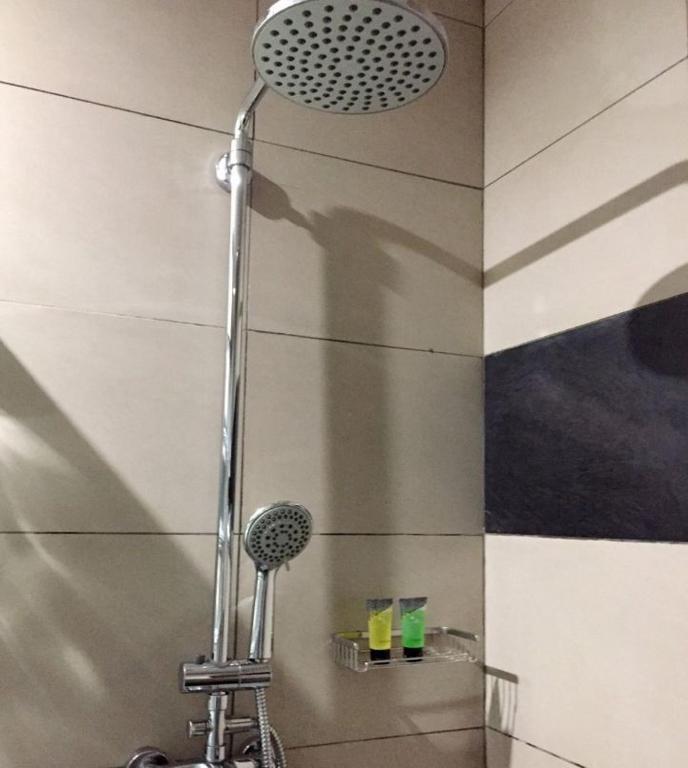 Hotel Plumeria moderns dušas aprīkojums ar tualetes piederumiem.