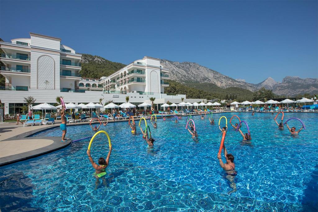 Viesnīca Dosinia Luxury Resort, cilvēki baseinā ar peldēšanas riņķiem, kalni fona