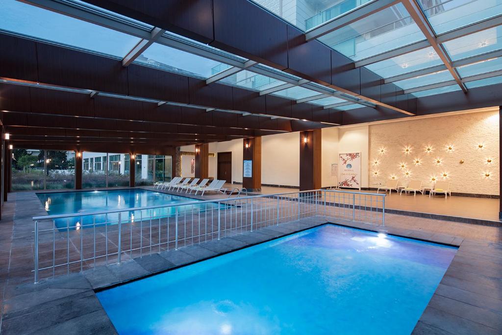 Iekštelpu baseins pie Dosinia Luxury Resort ar sauļošanās krēsliem
