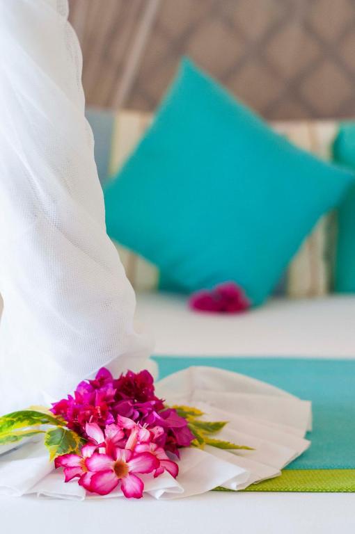 Dekoratīvi ziedi uz gultas Sultan Sands Island Resort numurā.