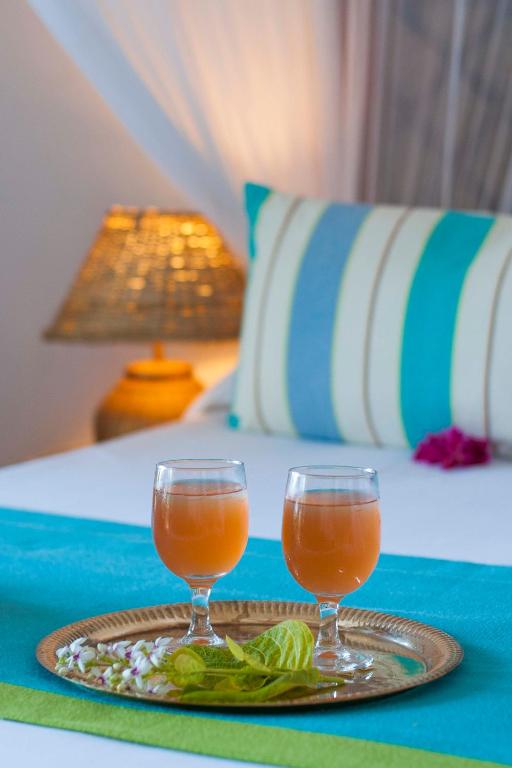 Divas glāzes dzērienu uz paliktņa Sultan Sands Island Resort numurā.