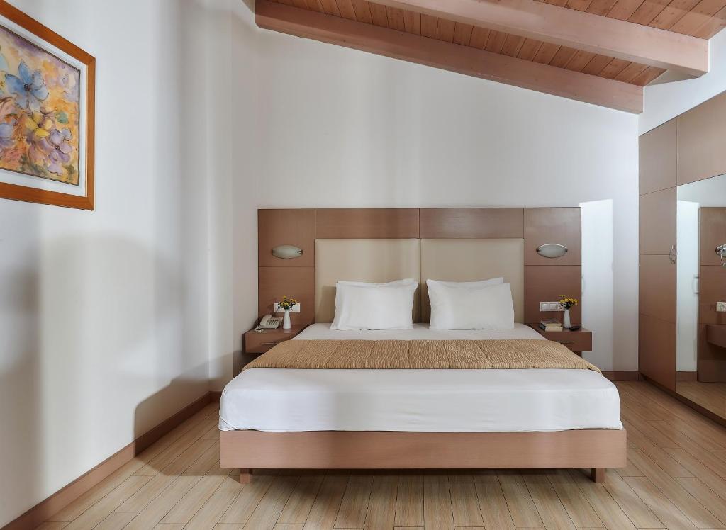 Mūsdienīgs viesnīcas numurs ar dubulto gultu, koka griestiem un gaišiem toņiem. Interjerā ir iekļauts mākslas darbs un ziedi uz galda.