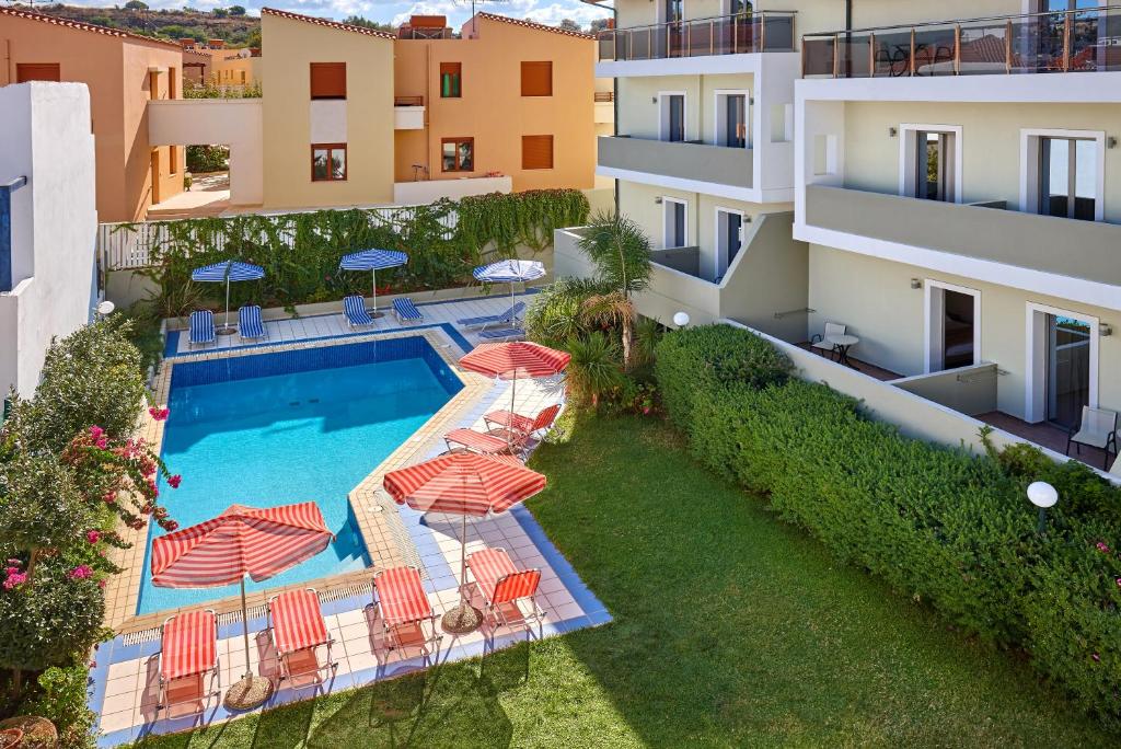 Baseins ar sauļošanās krēsliem un parasoliem, ieskauts zaļām ainavām un ēkām. Ideāla vieta atpūtai un relaksācijai.