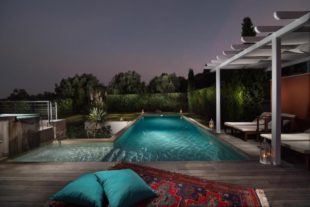 Mūsdienīga dārza zona ar baseinu, dekoratīvām gaismām un ērtām atpūtas vietām. Nakts apgaismojums rada relaksējošu atmosfēru.