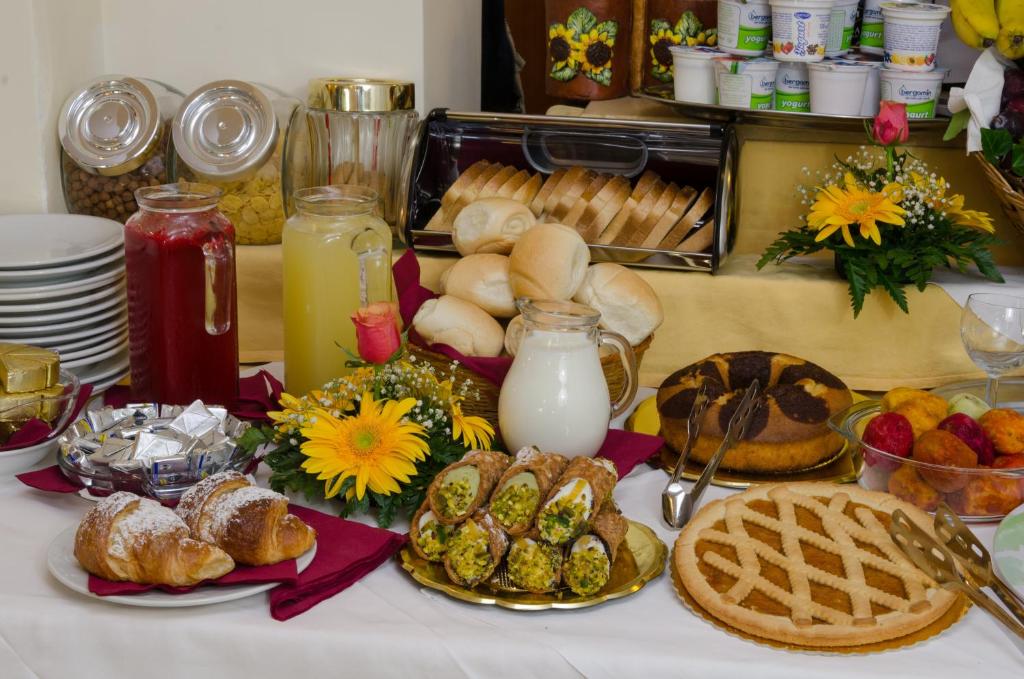 Bagātīga brokastu galda izvēle ar dažādiem konditorejas izstrādājumiem, dzērieniem un augļiem. Radoši izkārtoti gardumi, kas piešķir svētku noskaņu.