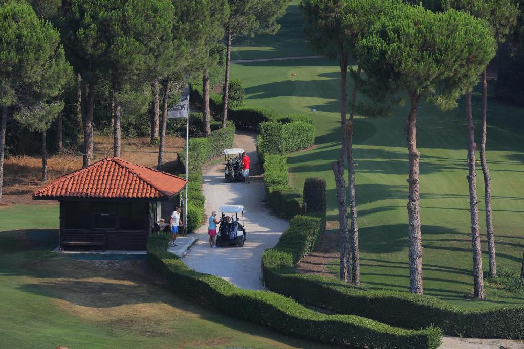 Golf laukums Sueno Hotels Golf Belek ar golfa ratiņiem un zaļo dabu.