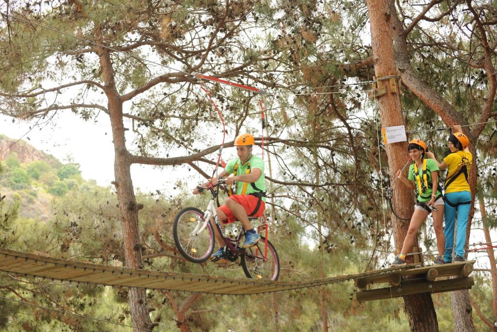 Cilvēks ar velosipēdu šķērso virs koka tilta pie Utopia World Hotel.