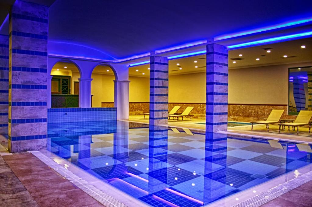 Utopia World Hotel iekštelpu baseins ar mīkstu apgaismojumu un saulessargiem