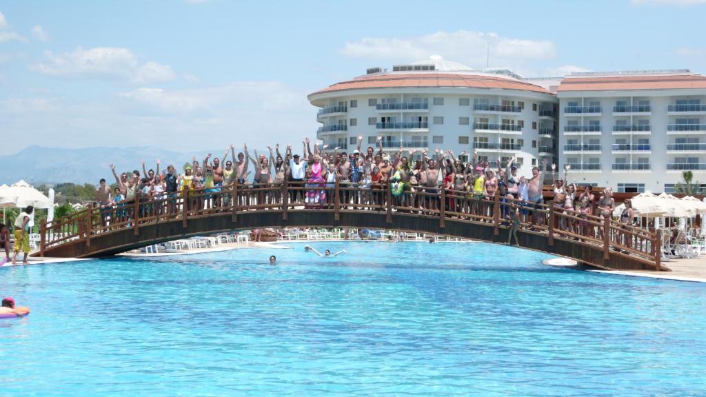 Viesi priecīgi pozē uz tilta pie Seaden Sea World Resort & Spa.