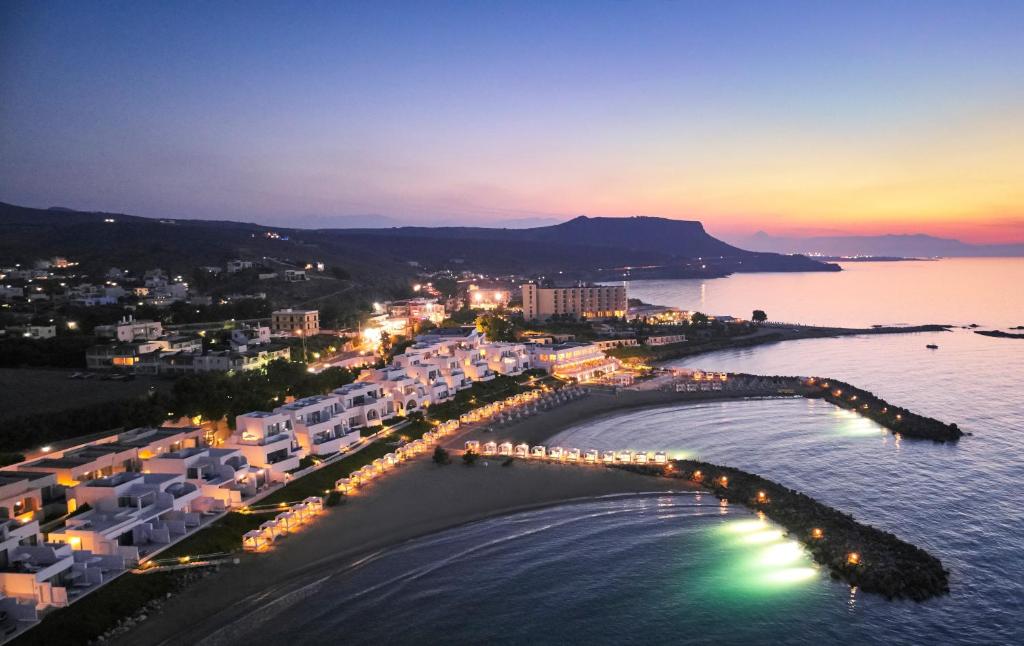 Knossos Beach Bungalows Resort piekrastes skats ar miera un saulrieta noskaņu.