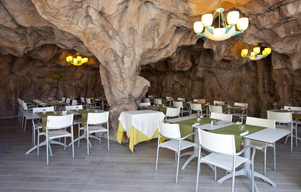 Restorāns ar unikālu akmens sienu un modernām lampām, piedāvā elegantu ēdināšanas vidi. Galdi ir klāti ar zaļām un dzeltenām galdautām, radot patīkamu atmosfēru.