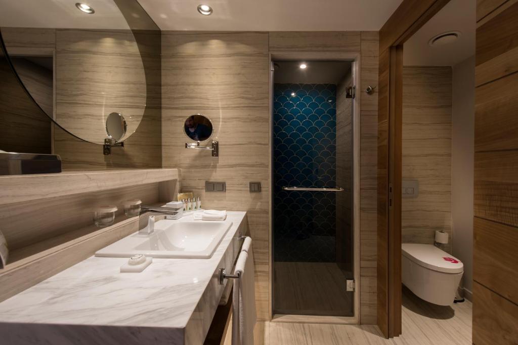 Mūsdienīgs vannas istaba Acanthus & Cennet Barut Collection ar dušu un izsmalcinātu dizainu.