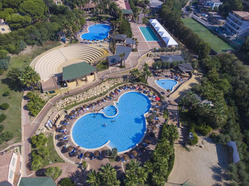 Viesnīcas kompleksa skats no augšas, kur redzami vairāki baseini, palmām apstādīta teritorija un atpūtas zonas. Ideāla vieta relaksācijai un izklaidei.