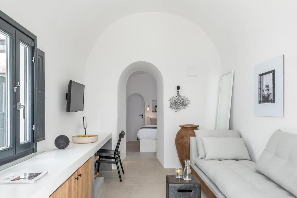 Mūsdienīga un minimālistiska viesistaba ar gaišām sienām, pelēku dīvānu un koka mēbelēm, kas rada patīkamu atmosfēru. Iekļauti logi ar melniem rāmjiem un dekoratīvi elementi, kas papildina interjeru.