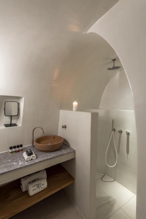 Moderns vannas istabas interjers ar apaļu dušu un elegantu izlietni. Balto sienu un dabīgo materiālu kombinācija rada mierīgu atmosfēru.