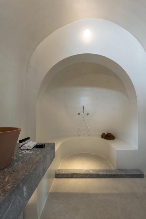 Mūsdienīgs vannas istabas interjers ar gludām līnijām, apgaismojumu un minimālistisku dizainu. Svaiga un relaksējoša atmosfēra ar akmens un māla elementiem.