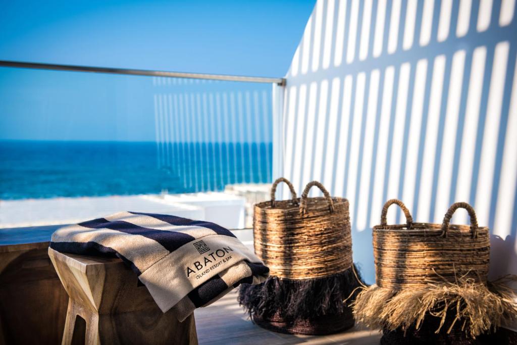 Kokvilnas segu ar Abaton Island Resort & Spa logo uz balkona piekrastē.
