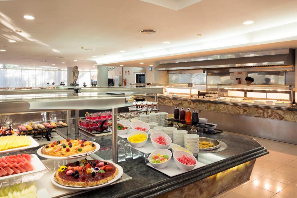 Patsvēriena bārs ar dažādiem desertiem, augļiem un saldējumu. Gaismas un moderna vide, kas aicina baudīt kārumus.