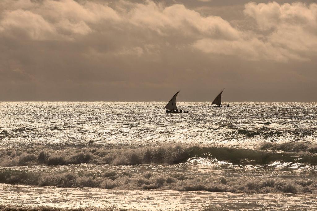 Burulaivas pie Sandies Baobab Beach piekrastē saulrietā.