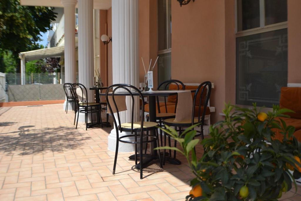 Ārtelpa ar galdiem un krēsliem, kas novietoti zemē, apzaļumota ar citrusu augiem. Ideāla vieta relaksācijai un atpūtai.