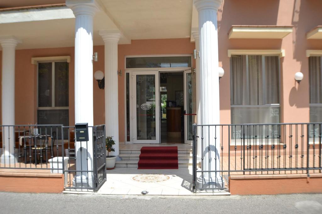 Ieeja viesnīcā ar kolonnām un sarkanu paklāju, apstrādāta ar gaišām krāsām un logiem, kas ļauj ienākt dabiskajai gaismai. Piekļuve terasei un ērtas sēdvietas ārpusē.