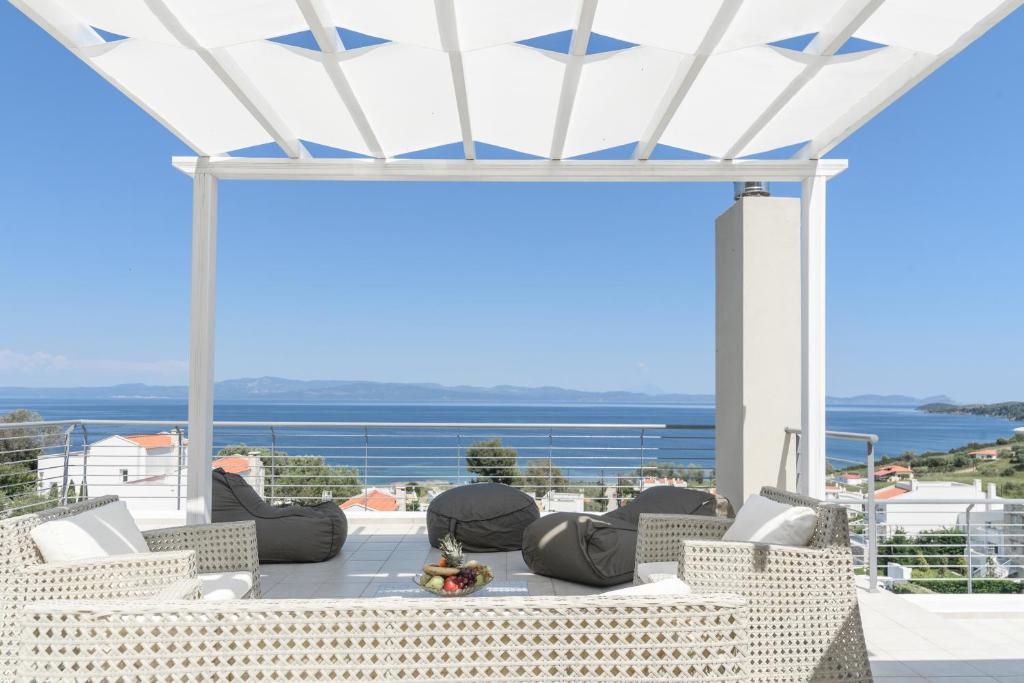 Mūsdienīgs terases dizains ar viegliem sēdekļiem un skatu uz jūru, radot relaksējošu atmosfēru. Ideāla vieta atpūtai un izklaidei brīvā dabā.