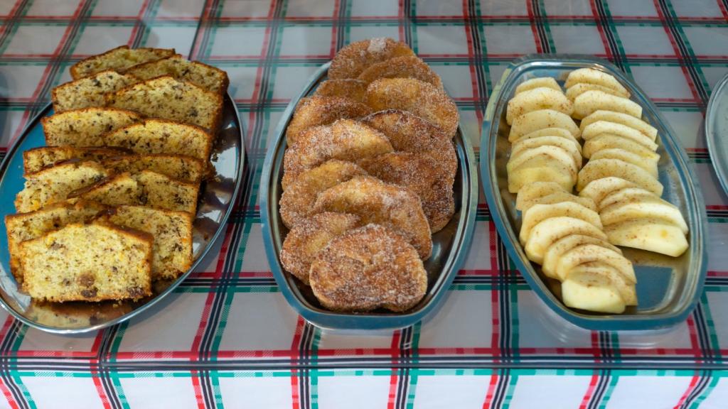 Ceptas preces uz sudraba šķīvjiem, tostarp banānu maizes šķēles, cepti āboli ar kanēli un garšīgi sagriezti āboli.
