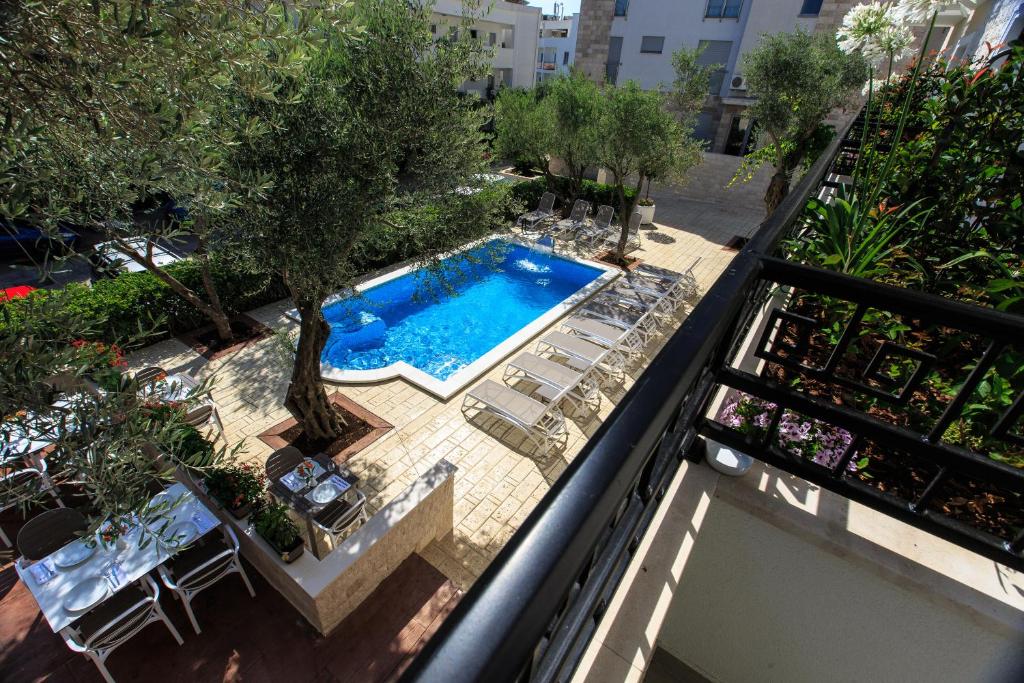 Baseins ar saulainu terasi un olīvu kokiem, apkārt ir atpūtas krēsli. Peldēšanās zona ir iestādīta zaļumos, radot mierīgu atmosfēru.