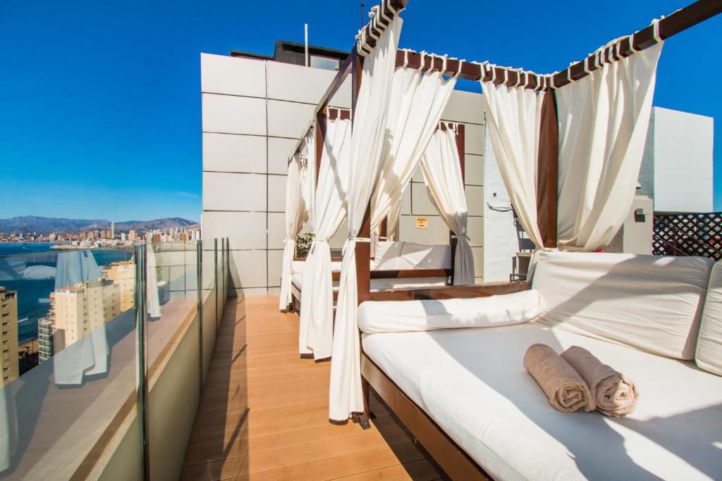 Moderns balkons ar gultām un aizkariem, kas piedāvā skatu uz pilsētu un jūru. Ideāla vieta atpūtai un relaksācijai.