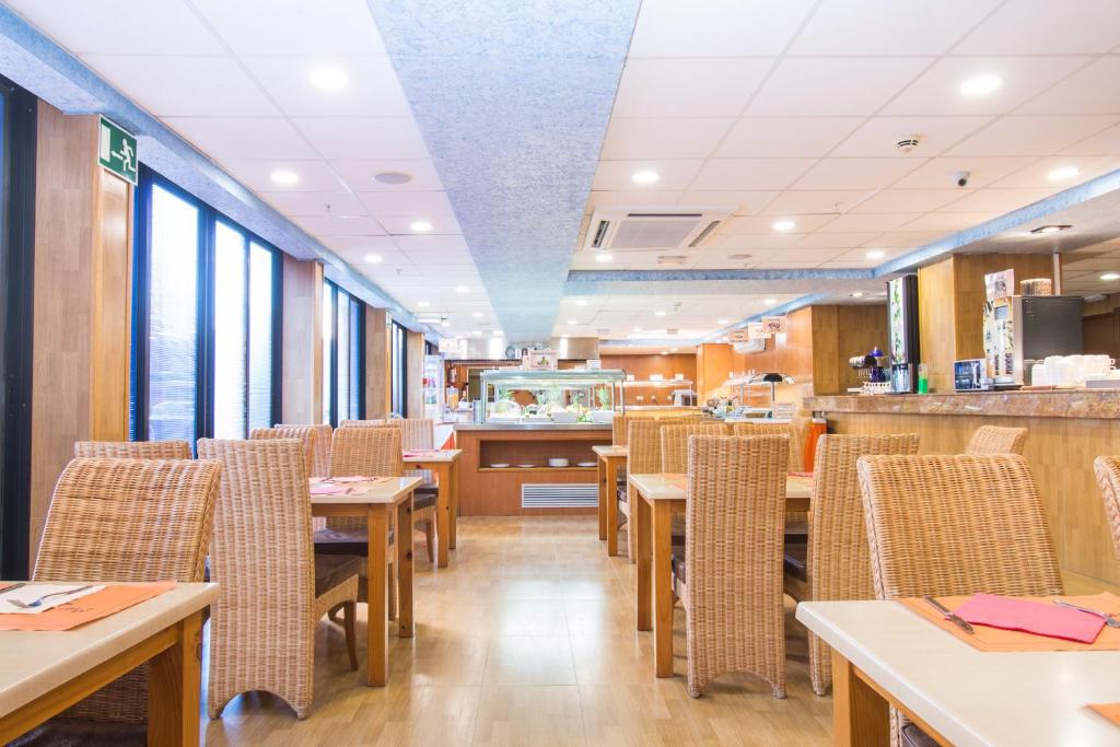 Gaisma un mūsdienīga restorāna iekšpuse ar koka un vītņu mēbelēm, plašiem logiem un viesmīlīgu atmosfēru. Ideāla vieta relaksējošai maltītei vai sociālai sanākšanai.